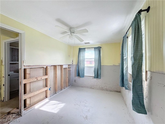 spare room featuring concrete flooring, visible vents, and a ceiling fan