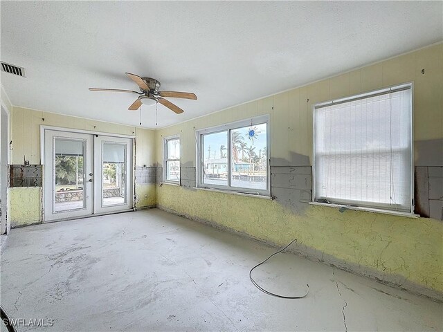 empty room with ceiling fan and french doors