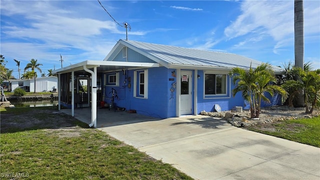 view of front of property with a front lawn and a carport