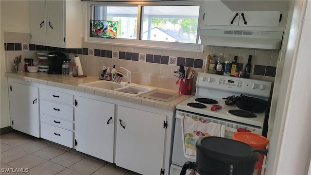 kitchen with under cabinet range hood, a sink, white cabinetry, electric stove, and backsplash