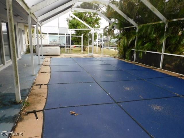 view of swimming pool featuring a patio, a hot tub, and glass enclosure