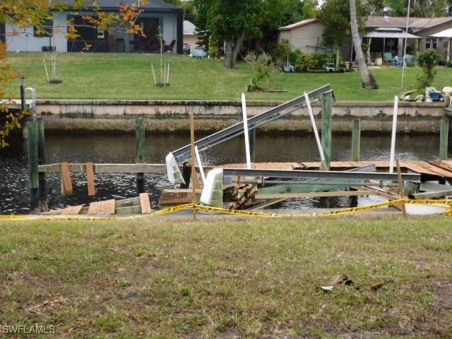 dock area with a yard and a water view