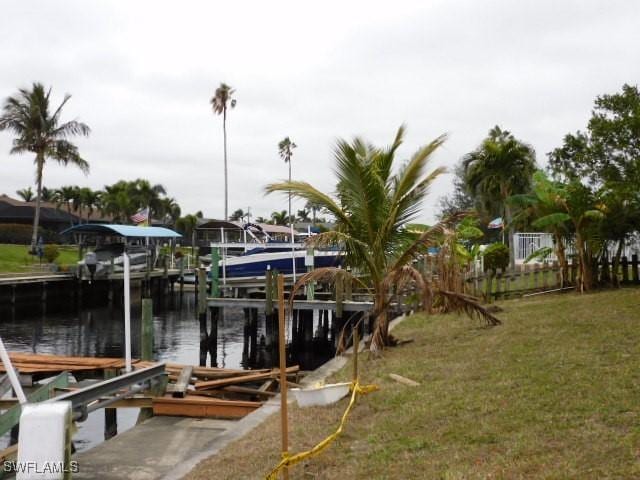 dock area with a lawn and a water view