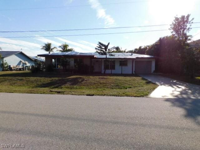 ranch-style home with a garage and a front lawn