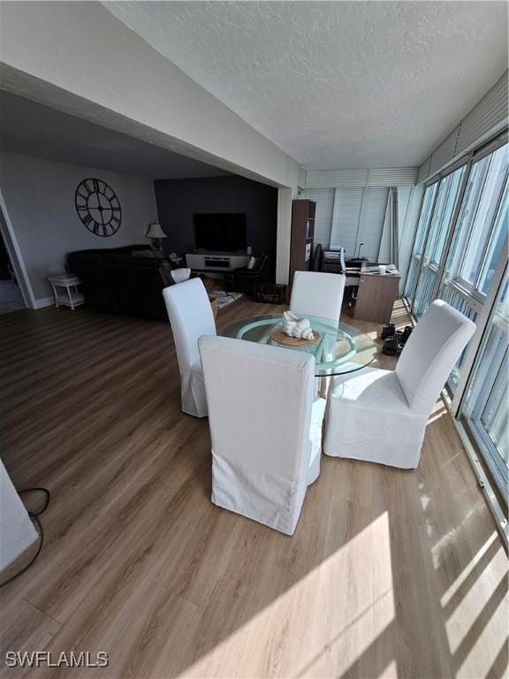 dining space with hardwood / wood-style flooring and a textured ceiling