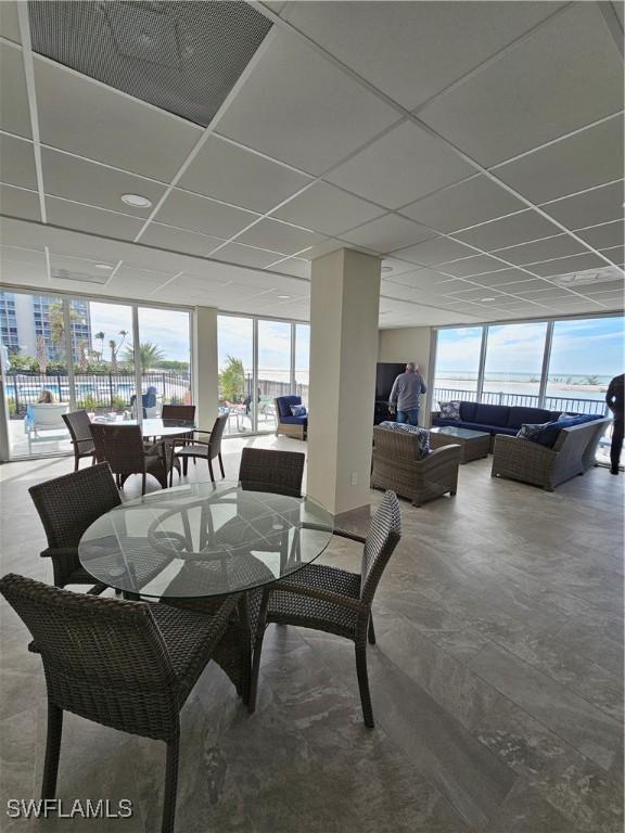 dining space featuring a drop ceiling, plenty of natural light, and expansive windows