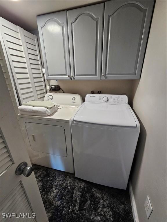 laundry room with washer and clothes dryer and cabinets