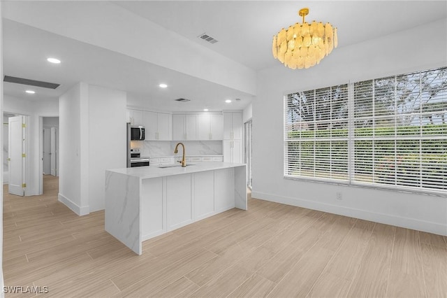 2657 Aft Ave, Naples, FL 34109 - kitchen featuring sink, white cabinetry, decorative light fixtures, appliances with stainless steel finishes, and backsplash