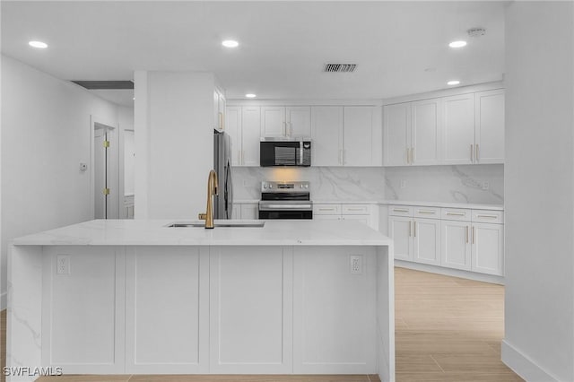 2657 Aft Ave, Naples, FL 34109 - kitchen featuring white cabinetry, appliances with stainless steel finishes, and a kitchen island with sink