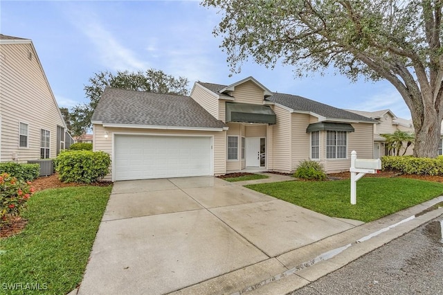 view of front of property with a garage, a front yard, and central AC unit