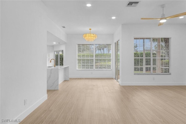 2657 Aft Ave, Naples, FL 34109 - unfurnished living room with sink, light hardwood / wood-style floors, and a healthy amount of sunlight