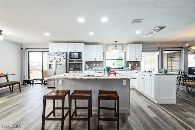 kitchen featuring wood-type flooring, black appliances, white cabinets, and a kitchen island