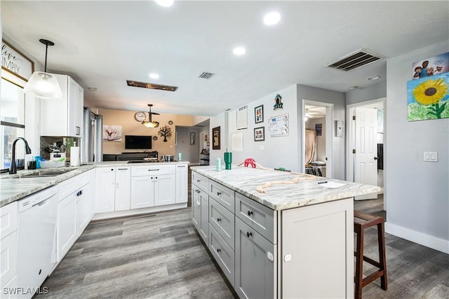 kitchen featuring white cabinetry, decorative light fixtures, dishwasher, and kitchen peninsula