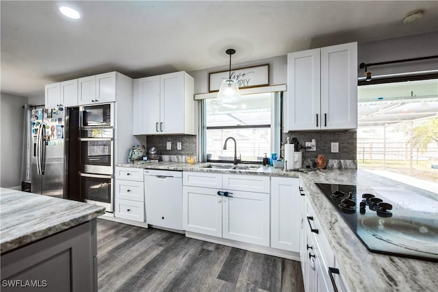 kitchen with white cabinetry, light stone counters, white dishwasher, dark wood-type flooring, and black electric cooktop