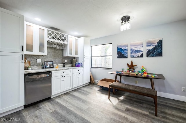 kitchen with tasteful backsplash, dishwasher, wood-type flooring, white cabinets, and light stone countertops