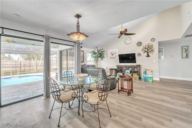 dining area featuring ceiling fan, lofted ceiling, and light wood-type flooring