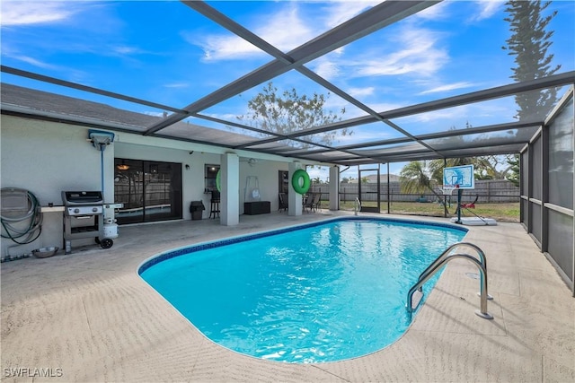 view of swimming pool featuring a patio and glass enclosure