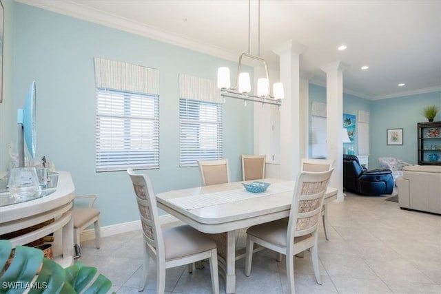 tiled dining area featuring crown molding, a chandelier, and decorative columns