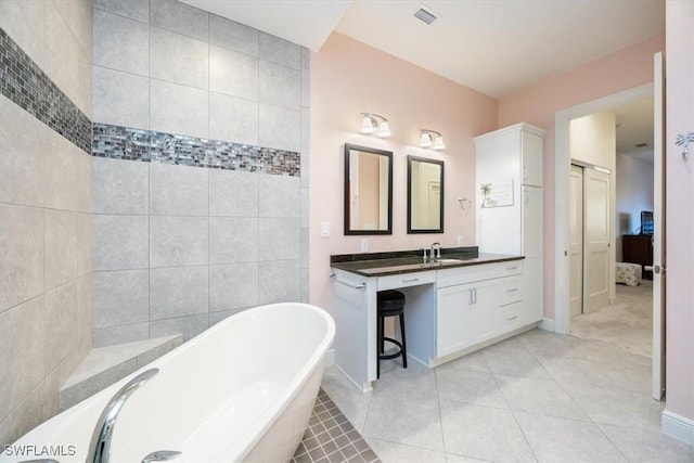 bathroom featuring vanity, a bathtub, and tile patterned floors