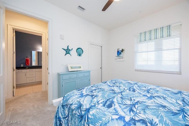 carpeted bedroom with ceiling fan and ensuite bath