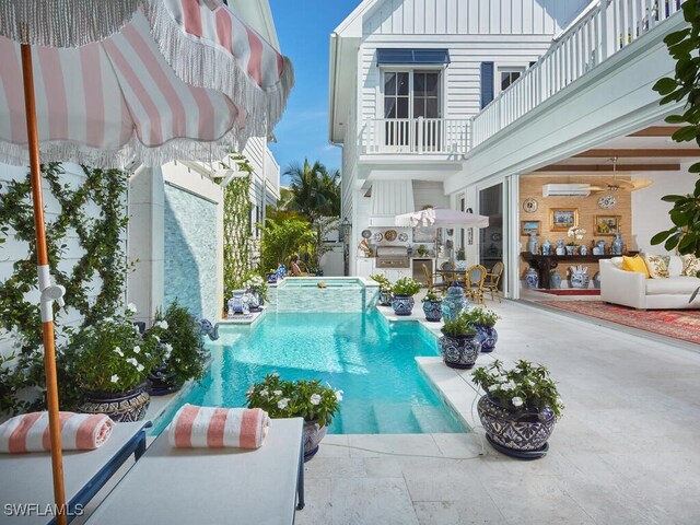 view of swimming pool featuring a patio, an AC wall unit, an outdoor kitchen, and an in ground hot tub