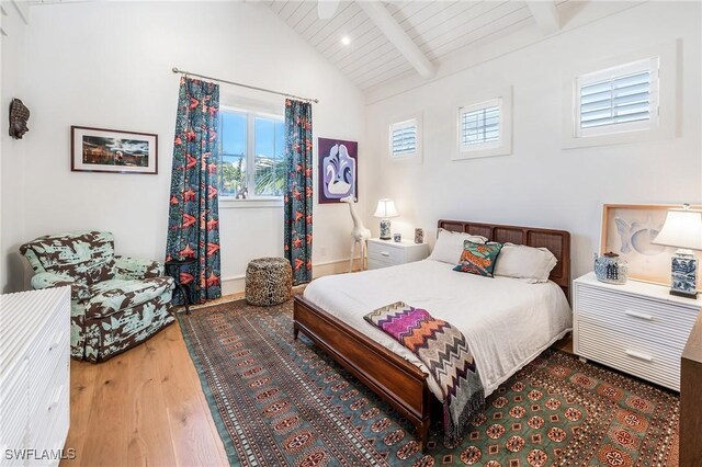 bedroom featuring lofted ceiling with beams, wood ceiling, multiple windows, and wood finished floors