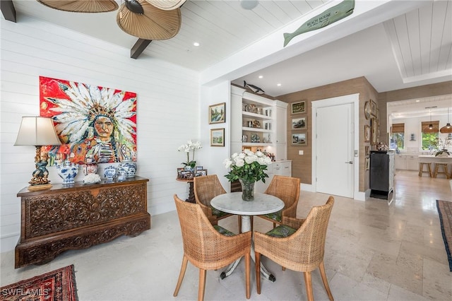 dining area with recessed lighting, beamed ceiling, and wooden walls