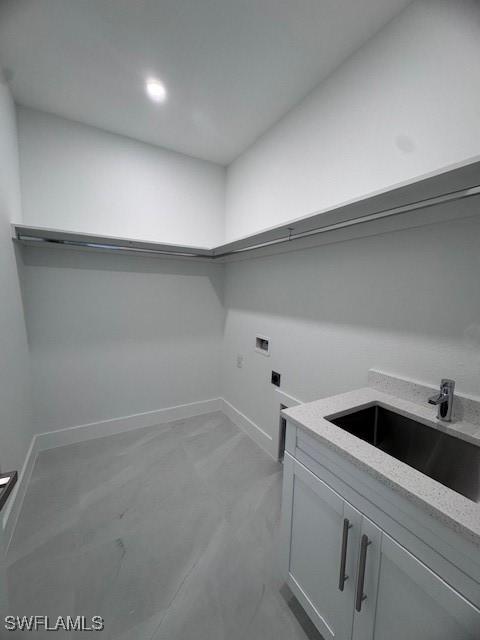 clothes washing area featuring cabinets, hookup for an electric dryer, hookup for a washing machine, and sink