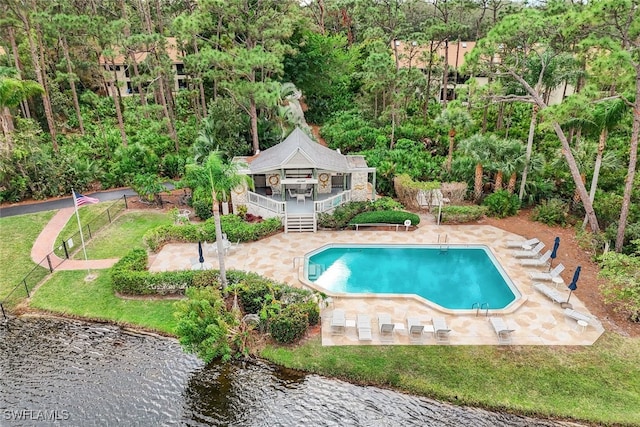 view of swimming pool featuring a patio, a yard, and a deck