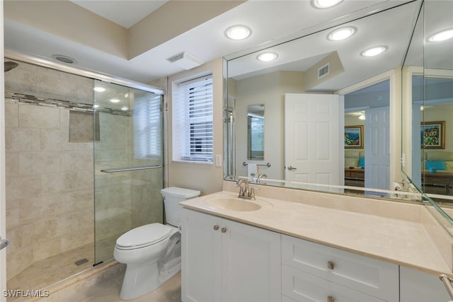 bathroom featuring vanity, an enclosed shower, and toilet