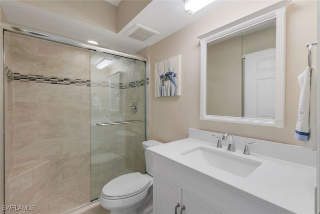 bathroom with vanity, a shower with shower door, and toilet