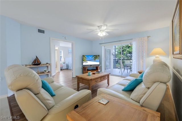 living room with light hardwood / wood-style flooring and ceiling fan