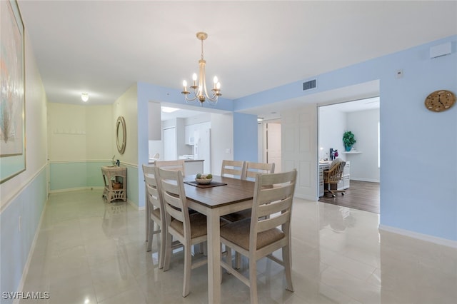 dining room with light tile patterned floors and a notable chandelier