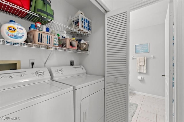 clothes washing area with washer and clothes dryer and light tile patterned floors