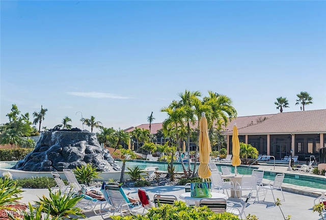 view of swimming pool with a patio and a sunroom