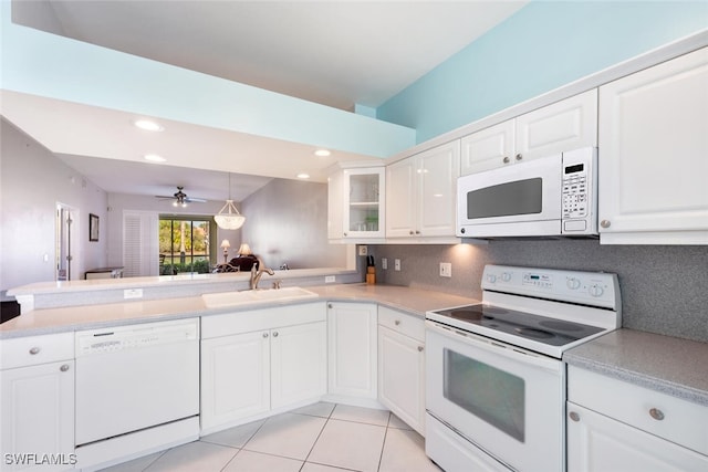 kitchen featuring white appliances, sink, white cabinetry, pendant lighting, and kitchen peninsula