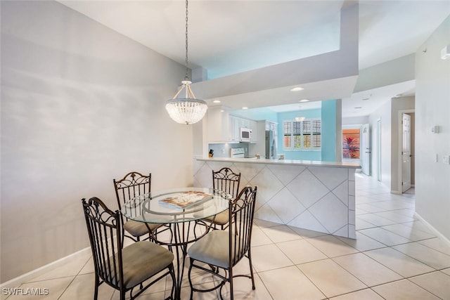 dining area with light tile patterned floors and an inviting chandelier