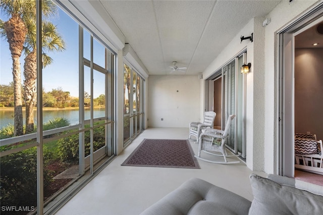 sunroom featuring a water view