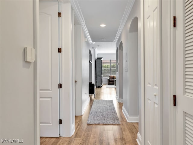 corridor featuring ornamental molding and light hardwood / wood-style floors