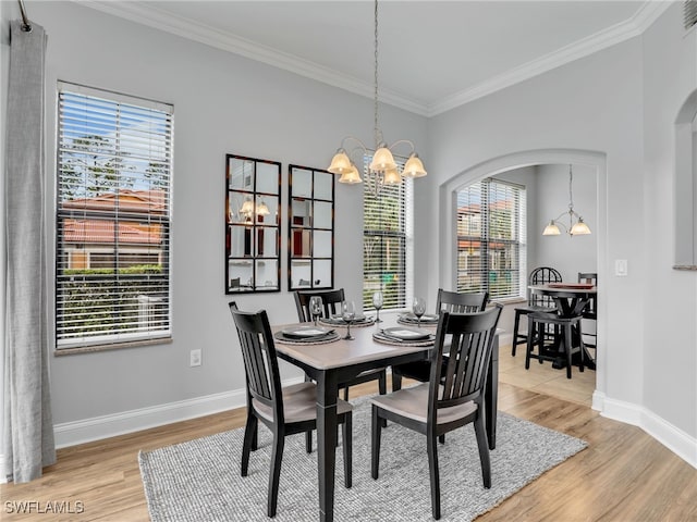 dining area with hardwood / wood-style floors, plenty of natural light, and a chandelier