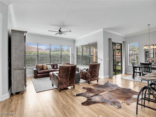 living room with ornamental molding, ceiling fan with notable chandelier, and light hardwood / wood-style flooring