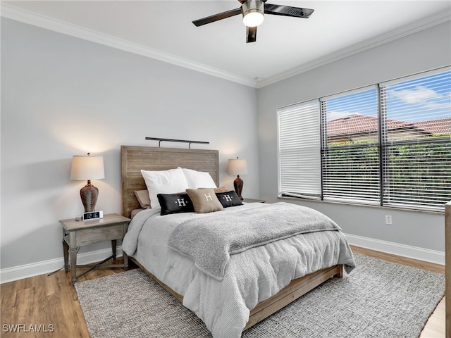 bedroom with ornamental molding, ceiling fan, and light wood-type flooring