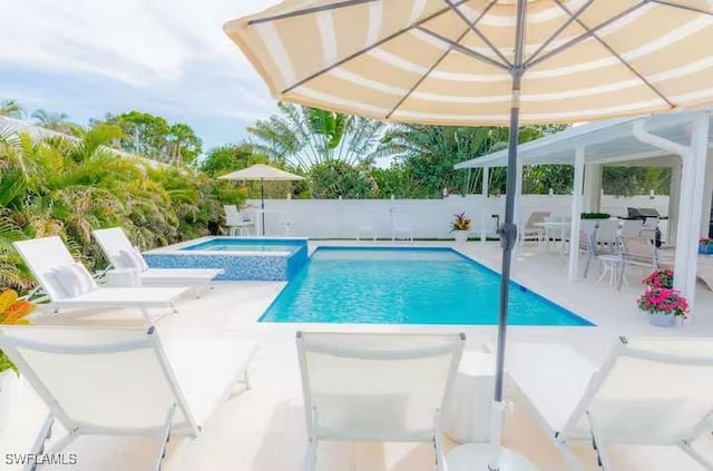 view of swimming pool featuring an in ground hot tub and a patio area