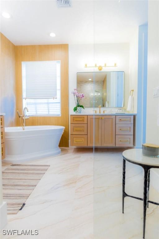 bathroom with vanity and a bath