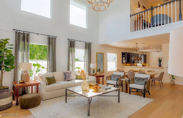 living room featuring a wealth of natural light, a chandelier, and light hardwood / wood-style flooring