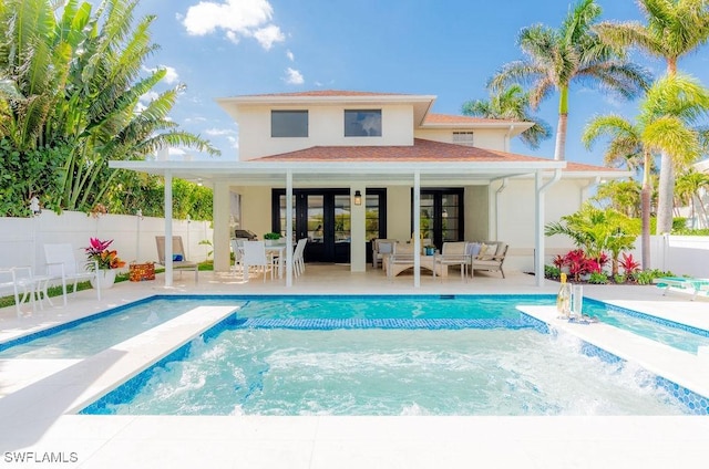 back of house featuring a fenced in pool, an outbuilding, a patio area, and french doors