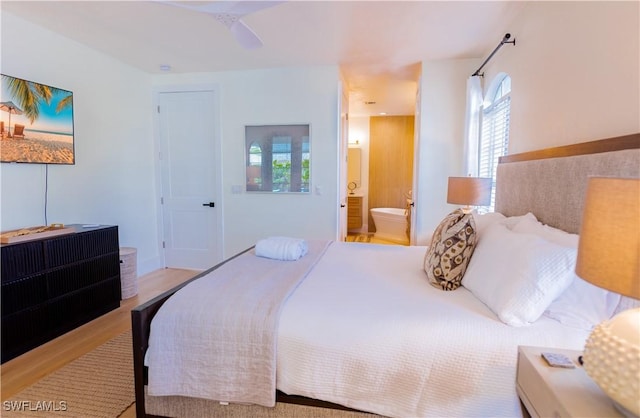 bedroom with ensuite bath and light hardwood / wood-style floors