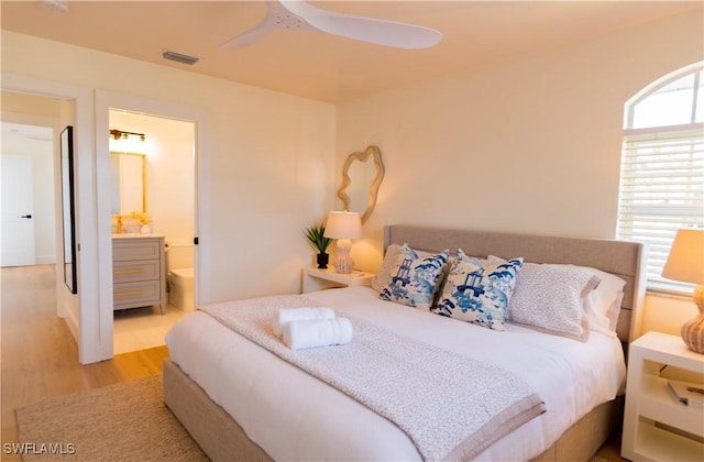 bedroom featuring ensuite bath and light hardwood / wood-style floors