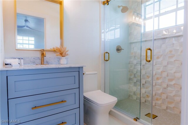 bathroom featuring vanity, an enclosed shower, and toilet