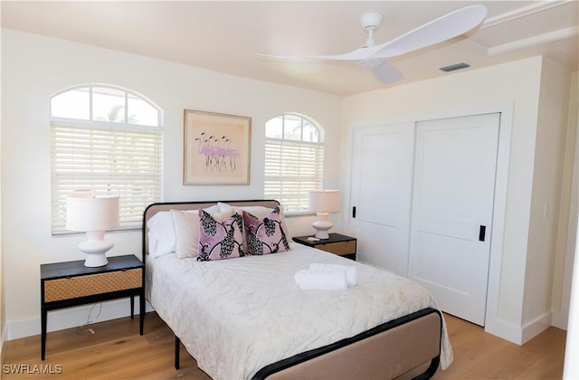 bedroom with ceiling fan, a closet, and light hardwood / wood-style flooring